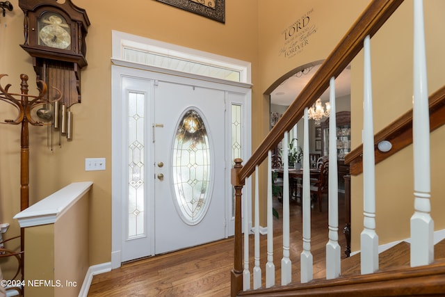 entrance foyer with a wealth of natural light, a chandelier, and wood-type flooring