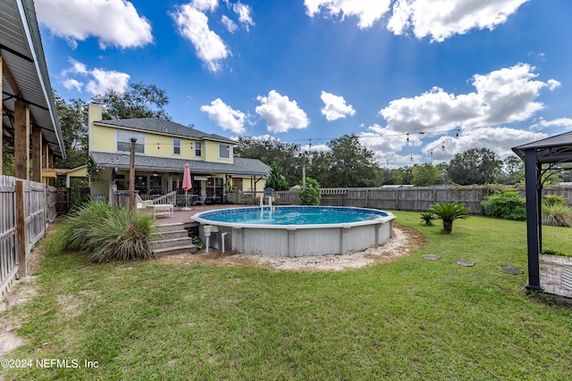 view of swimming pool with a deck and a lawn