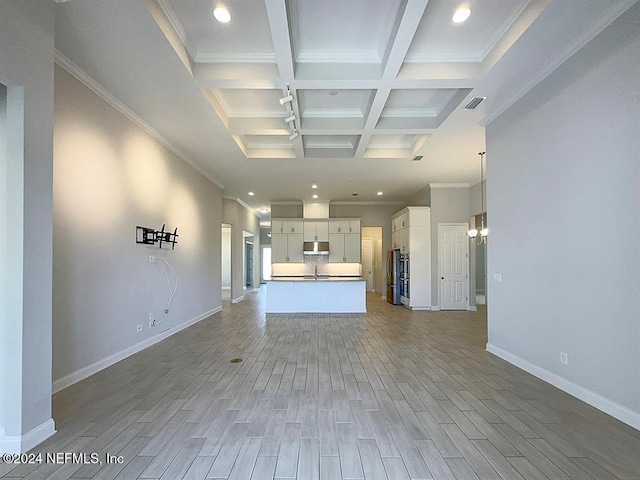 unfurnished living room with light hardwood / wood-style floors, sink, beam ceiling, and coffered ceiling