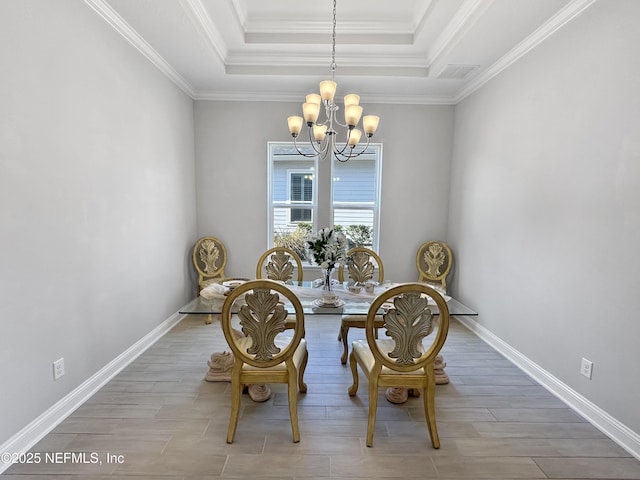 dining space with a chandelier, wood finished floors, visible vents, baseboards, and a tray ceiling