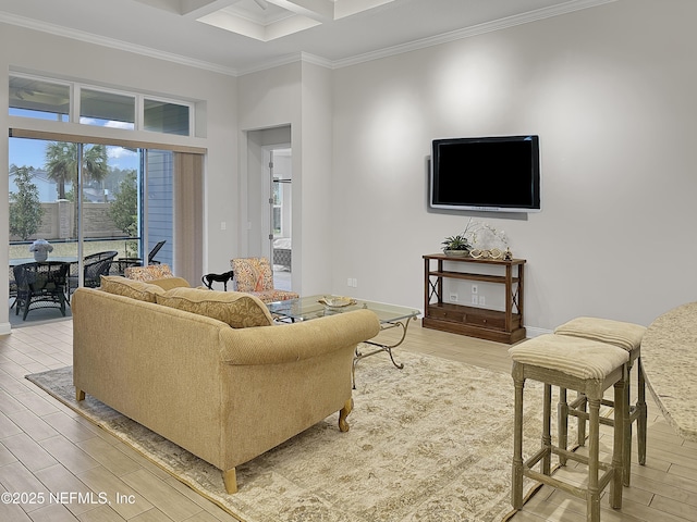 living room with ornamental molding, wood finished floors, a towering ceiling, and baseboards