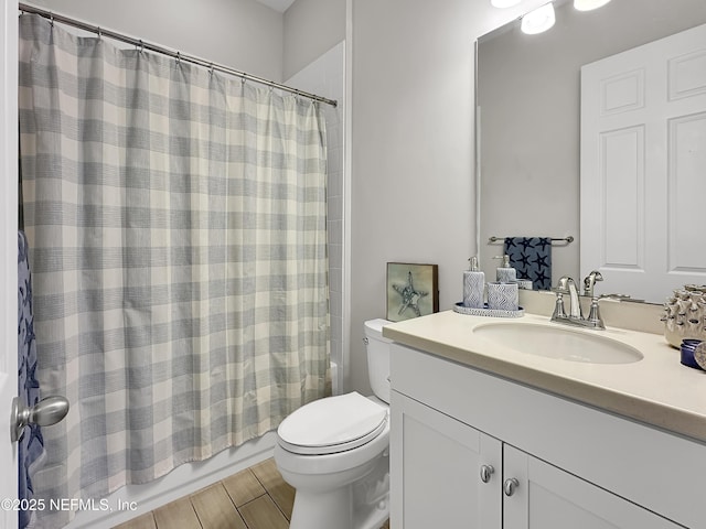 bathroom featuring toilet, wood tiled floor, shower / bath combo, and vanity