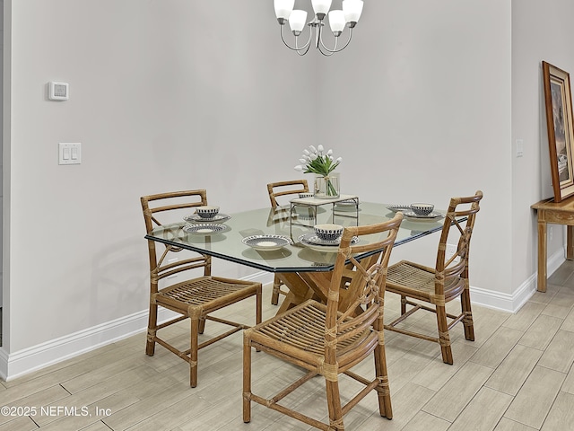 dining room featuring an inviting chandelier, baseboards, and wood finish floors