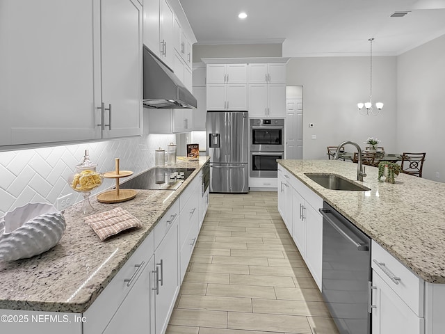 kitchen featuring decorative light fixtures, a center island with sink, appliances with stainless steel finishes, a sink, and under cabinet range hood