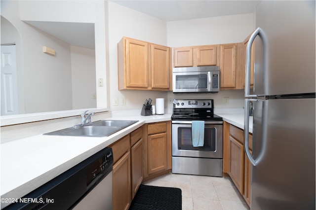 kitchen featuring light tile patterned floors, appliances with stainless steel finishes, and sink