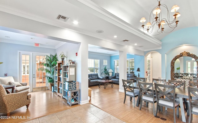 dining space featuring french doors, crown molding, and light wood-type flooring