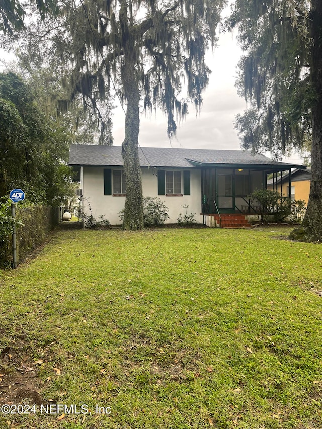 rear view of house featuring a yard