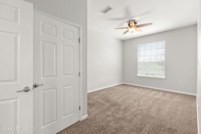 carpeted spare room featuring ceiling fan