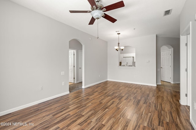 interior space with ceiling fan with notable chandelier and dark hardwood / wood-style flooring