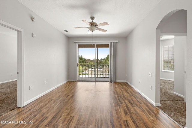 empty room with ceiling fan and dark hardwood / wood-style floors