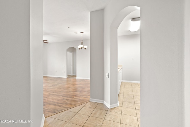 hall featuring light hardwood / wood-style flooring and a notable chandelier