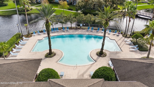 view of swimming pool with a water view and a patio