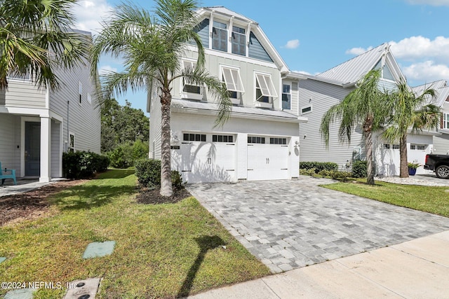 270 Clifton Bay Lp, Saint Johns, FL 32259 - coastal home featuring board and batten siding, decorative driveway, metal roof, an attached garage, and a front yard