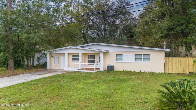 view of front of home with a front lawn and central AC