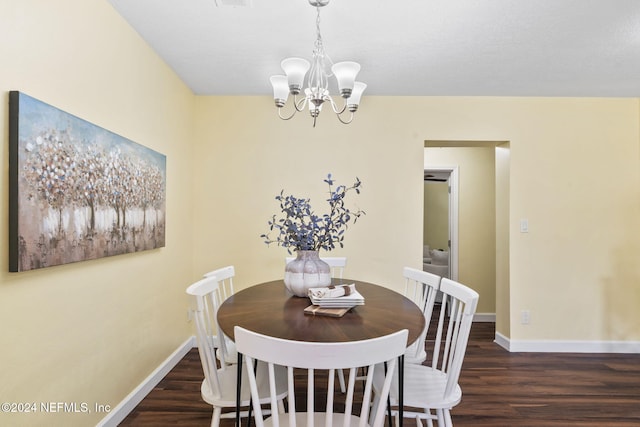 dining space with dark hardwood / wood-style floors and an inviting chandelier