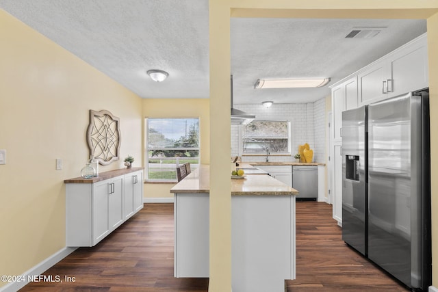 kitchen featuring white cabinets, stainless steel appliances, and dark hardwood / wood-style floors