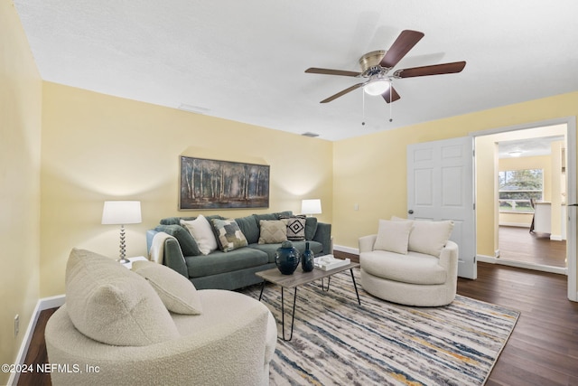 living room featuring dark wood-type flooring and ceiling fan