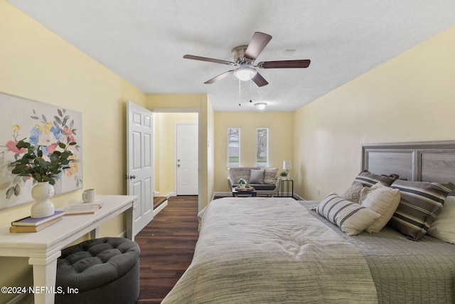 bedroom with a textured ceiling, dark wood-type flooring, and ceiling fan