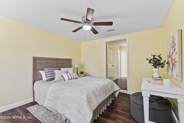 bedroom with a textured ceiling, dark hardwood / wood-style floors, and ceiling fan