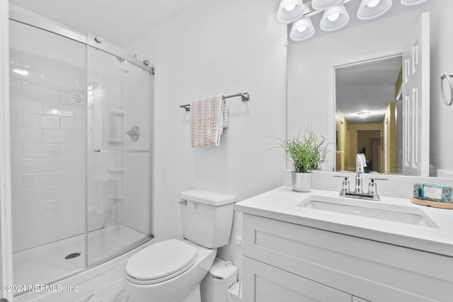 bathroom with walk in shower, vanity, and toilet