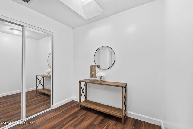 interior space with dark hardwood / wood-style flooring and a skylight