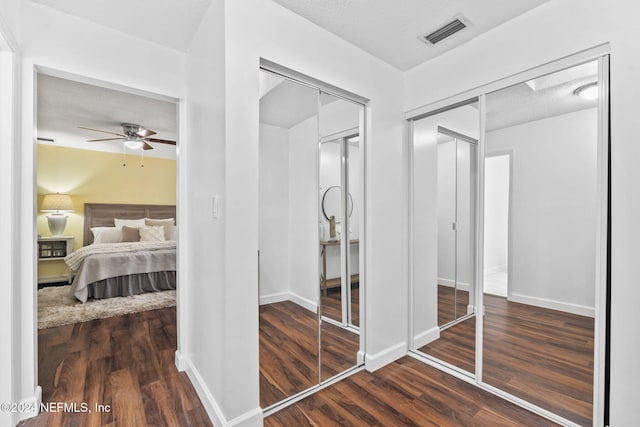 bedroom with ceiling fan, dark hardwood / wood-style floors, and a textured ceiling