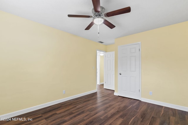 spare room featuring dark wood-type flooring and ceiling fan