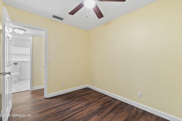 spare room with dark wood-type flooring and ceiling fan