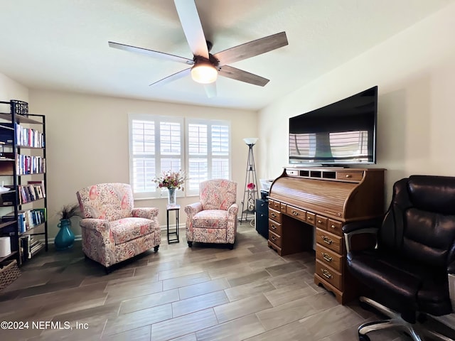 living area featuring wood-type flooring and ceiling fan