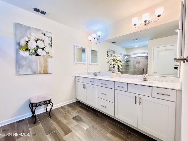 bathroom featuring a shower with shower door and vanity