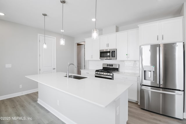 kitchen featuring white cabinetry, appliances with stainless steel finishes, sink, and a kitchen island with sink