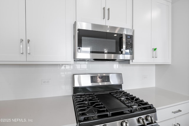 kitchen with tasteful backsplash, stainless steel appliances, and white cabinets