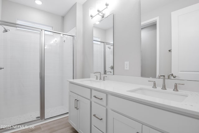 bathroom with vanity, an enclosed shower, and hardwood / wood-style flooring