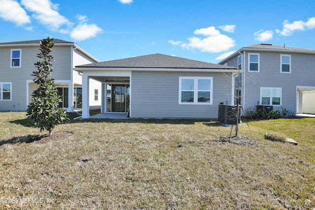 back of house with central AC and a lawn