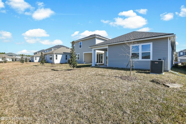 back of house featuring central AC unit and a lawn