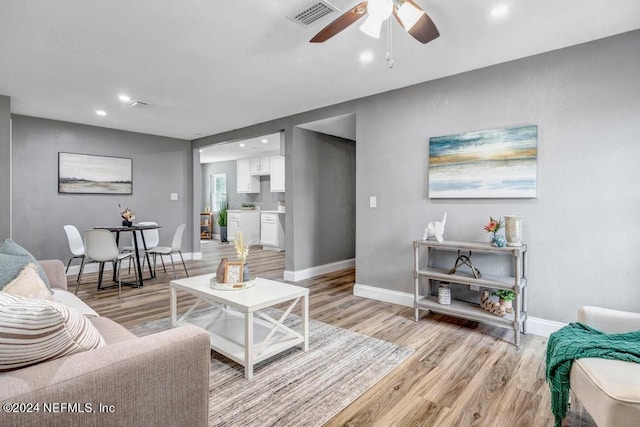 living room with ceiling fan and light wood-type flooring