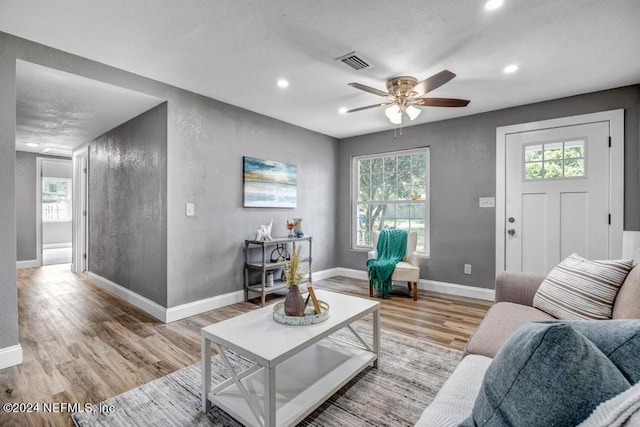 living room with light wood-type flooring and ceiling fan