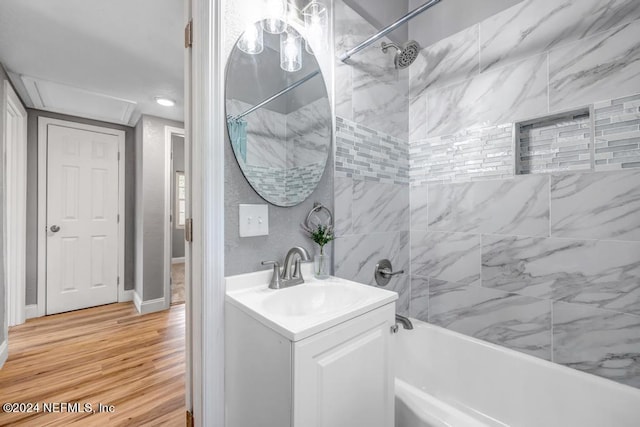 bathroom with tiled shower / bath combo, vanity, and hardwood / wood-style flooring