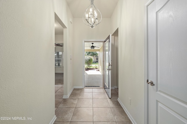 entryway with light tile patterned floors and ceiling fan with notable chandelier