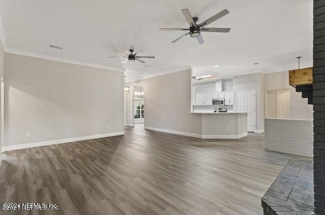 unfurnished living room featuring dark wood-type flooring, a textured ceiling, and crown molding