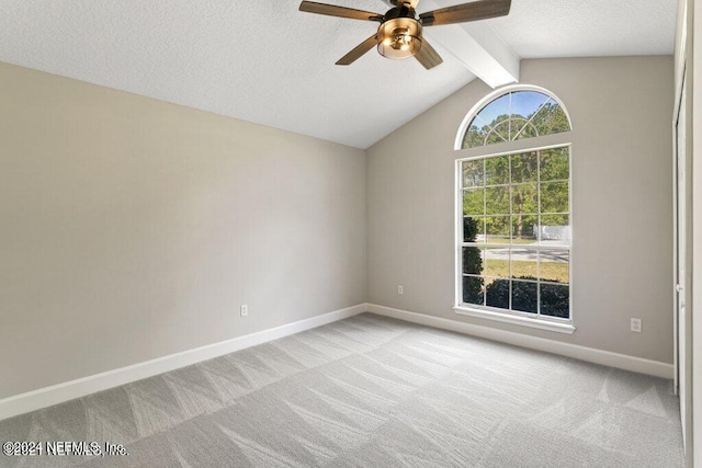 carpeted empty room featuring a textured ceiling, vaulted ceiling with beams, and ceiling fan