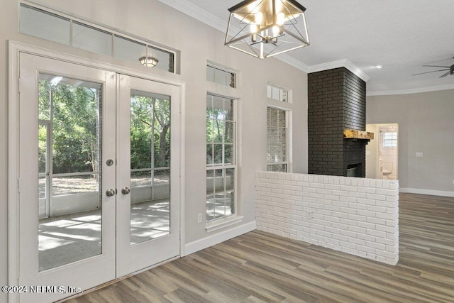 doorway to outside with wood-type flooring, ceiling fan with notable chandelier, and french doors