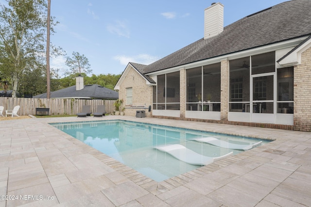 view of pool featuring a sunroom and a patio