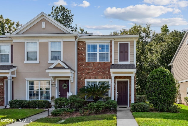 townhome / multi-family property featuring a front yard