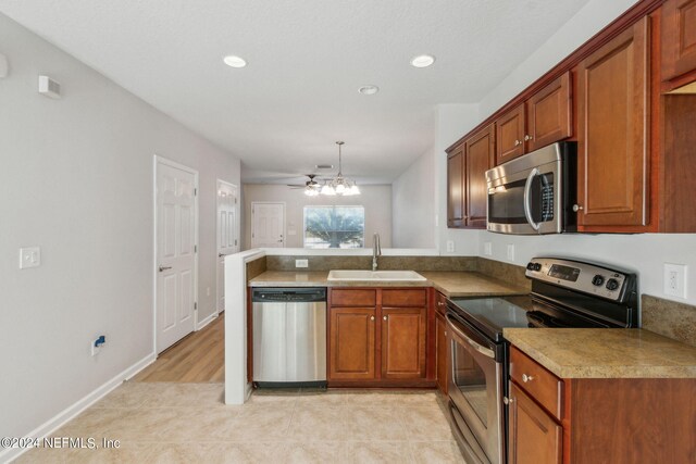 kitchen featuring kitchen peninsula, light tile patterned floors, pendant lighting, stainless steel appliances, and sink