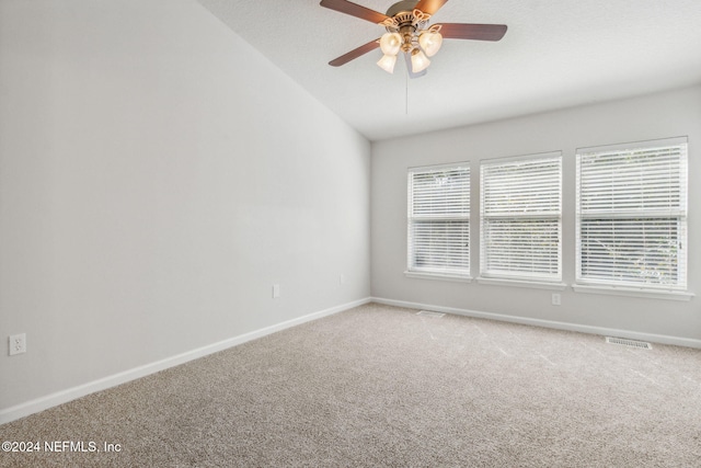 carpeted empty room featuring vaulted ceiling and ceiling fan