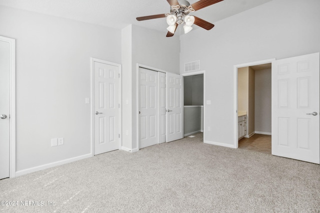 unfurnished bedroom featuring connected bathroom, ceiling fan, and light colored carpet