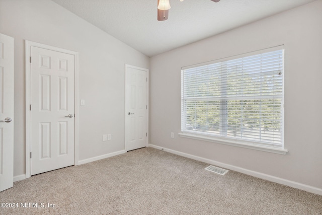 unfurnished bedroom with vaulted ceiling, ceiling fan, and light colored carpet