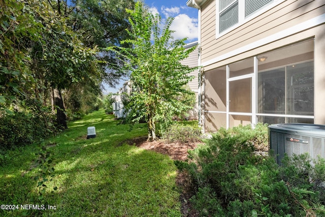 view of yard with cooling unit and a sunroom