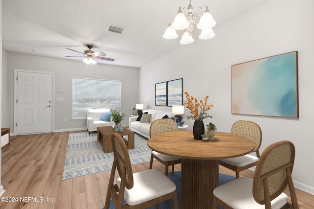 dining area featuring light wood-type flooring and ceiling fan with notable chandelier